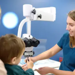 Okulista bada wzrok dziecka, które może mieć astygmatyzm i nadwzroczność.