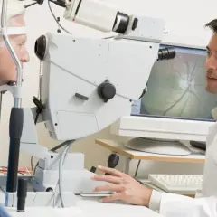 Okulista bada oko pacjenta za pomocą specjalistycznego sprzętu.