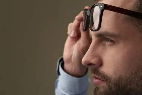 Mężczyzna poprawia okulary, które korygują największą wadę wzroku.