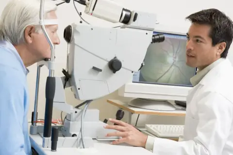 Okulista bada oko pacjenta za pomocą specjalistycznego sprzętu.