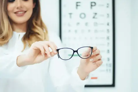 Okulista prezentuje okulary, które mogą pomóc w korekcji astygmatyzmu 0.5.