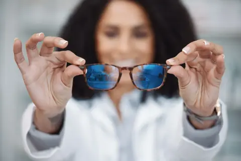 Okulista prezentuje okulary, które mogą być szkłami relaksacyjnymi lub progresywnymi, pomagając w wyborze najlepszego rozwiązania.