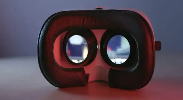 Gogle VR, które oferują niesamowite widzenie przestrzenne, leżą na stole. Czerwone światło podkreśla ich futurystyczny design.