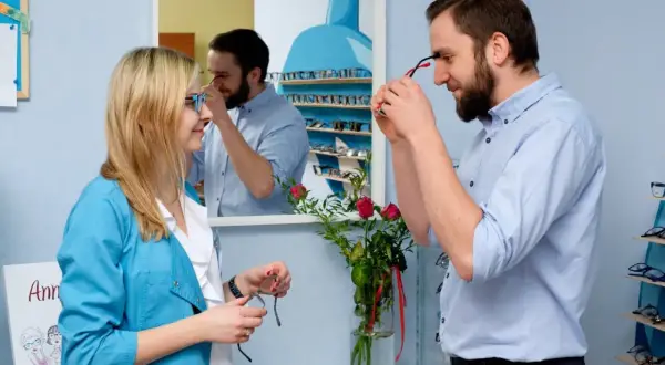 Optometrysta pomaga kobiecie dobrać okulary, być może w ramach terapii na daltonizm.