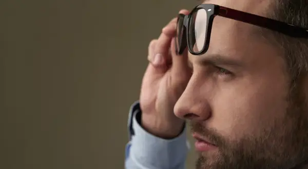 Mężczyzna poprawia okulary, które korygują największą wadę wzroku.