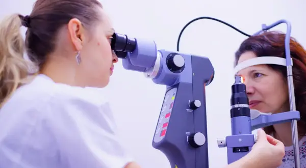 Okulista bada oko pacjentki, co może być częścią diagnostyki amblyopii leczenie u dorosłych.