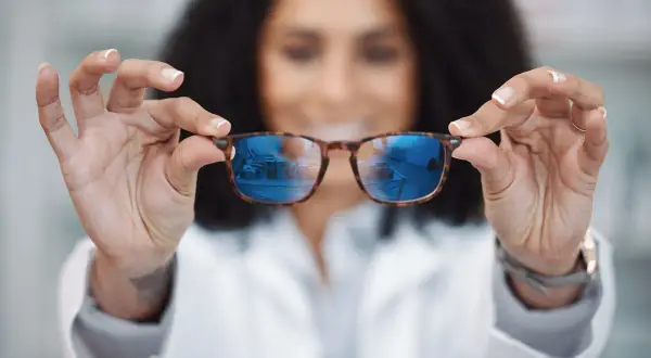 Okulista prezentuje okulary, które mogą być szkłami relaksacyjnymi lub progresywnymi, pomagając w wyborze najlepszego rozwiązania.