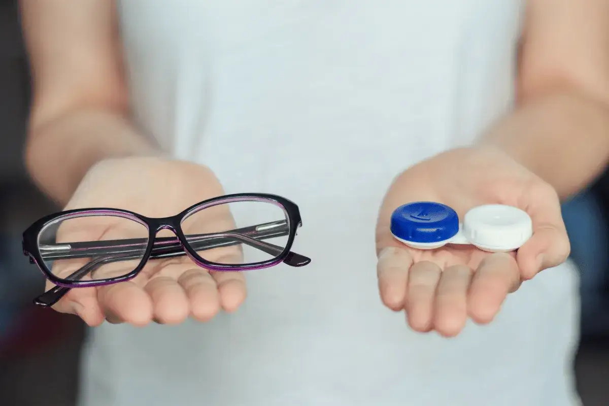 Dwie dłonie prezentują wyb&oacute;r: okulary i pojemnik na soczewki. Czy można nosić soczewki i okulary jednocześnie? Decyzja należy do Ciebie.
