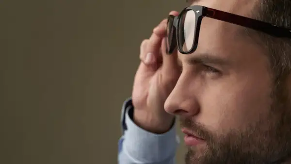 Mężczyzna poprawia okulary, które korygują największą wadę wzroku.