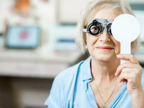 Starsza kobieta z przyrządem optometrycznym, badanie wzroku. Może to być związane z pogorszeniem wzroku ICD 10.