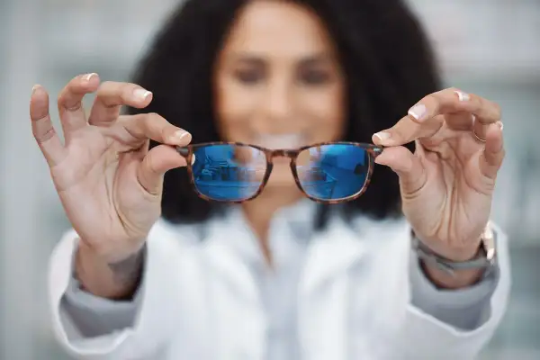 Okulista prezentuje okulary, które mogą być szkłami relaksacyjnymi lub progresywnymi, pomagając w wyborze najlepszego rozwiązania.